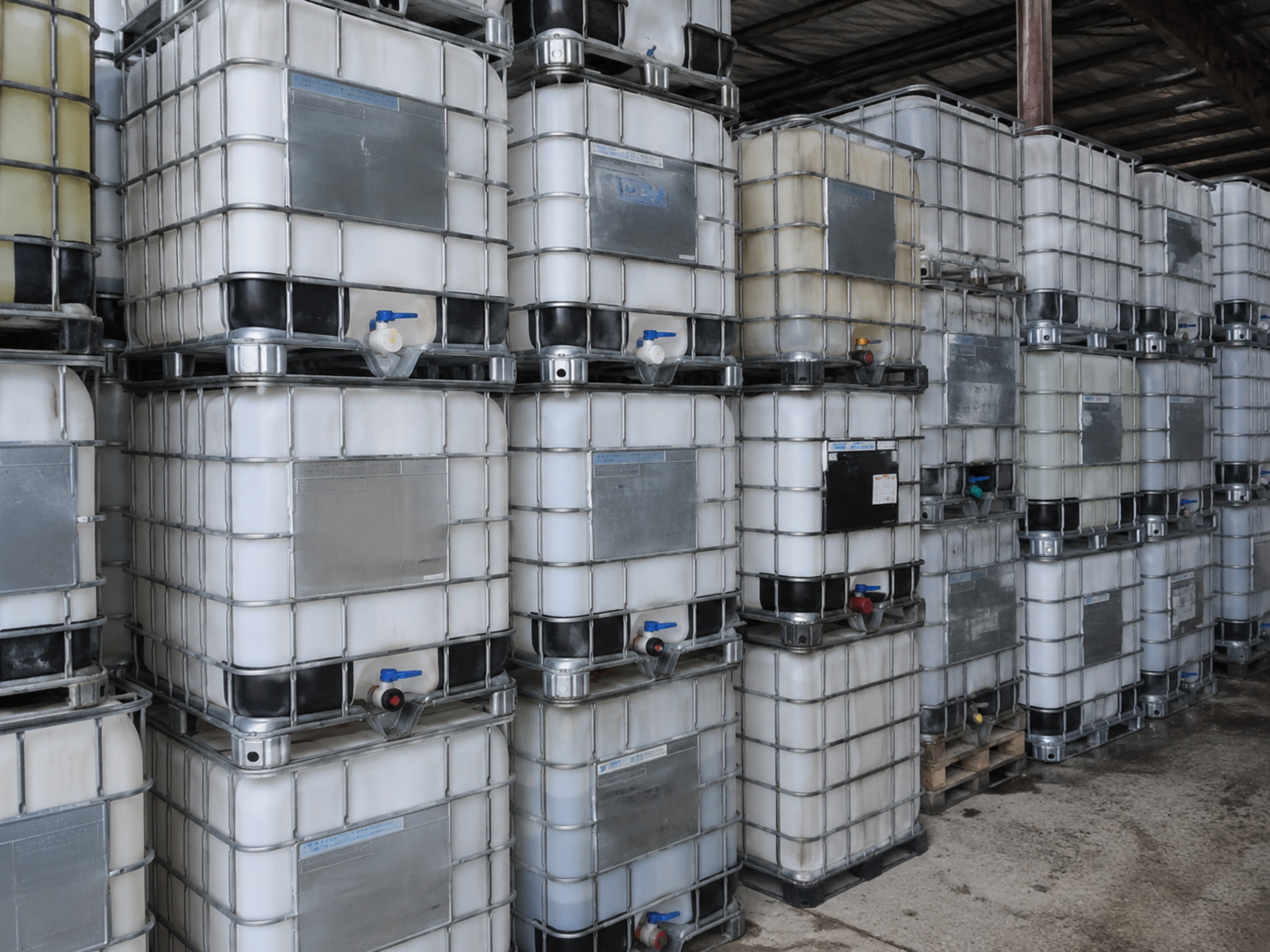 Stacked used IBC totes in the Reclaim warehouse, graded and ready for resale